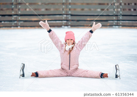 Little adorable girl sitting on ice with skates after fall Little adorable girl sitting on ice with skates after fall 61356344