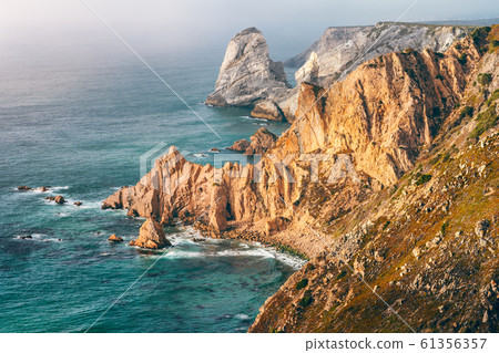 Sintra, Portugal. Rocky coastline between Cape Roca and Praia da Ursa in evening sunset light and Atlantic Ocean 61356357
