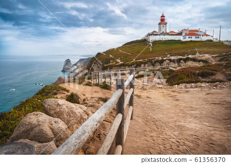 Sintra Portugal. Cape Roca and red lighthouse. Cabo da Roca. Travel and tourism landmark with beautiful coastline cliffs of atlantic ocean Sintra Portugal. Cape Roca and red lighthouse. Cabo da Roca. Travel and tourism landmark with beautiful coastline cliffs of atlantic ocean 61356370