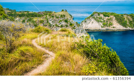 Path on Edge of Cliff near Atuh Beach, North Coastline of Nusa Penida, Bali, Indonesia Path on Edge of Cliff near Atuh Beach, North Coastline of Nusa Penida, Bali, Indonesia 61356394