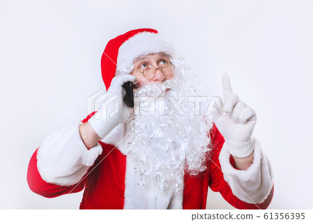 Portrait of happy Santa Claus talking on phone and showing up Portrait of happy Santa Claus talking on phone and showing up 61356395