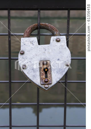 hanged padlock on a fence of a bridge for love 61356458