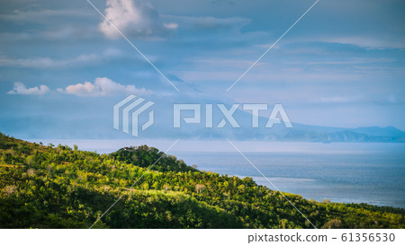Beautifull evening view to St. Agung Vulcano on Bali from Nusa Penida Island. Partly Covered by Clouds. Indonesia 61356530