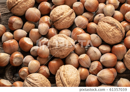 Closeup of whole walnuts and hazelnuts on a table 61357039