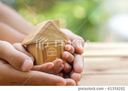 hand is giving a model of a house to child's hand, 61359282