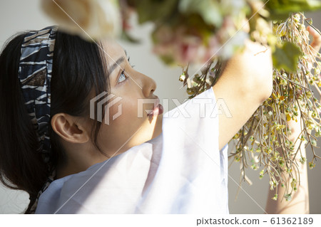A woman adorning flowers A woman adorning flowers 61362189