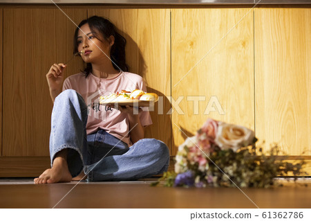 Woman eating in her room Woman eating in her room 61362786