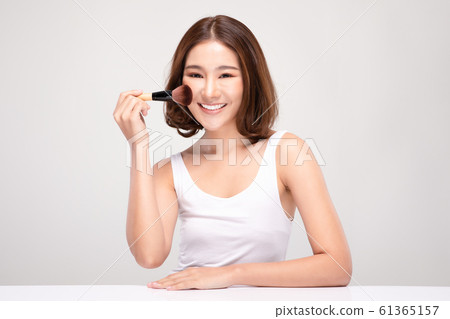 Beautiful Asian young woman smile and holding make up brush with healthy Clean and Fresh skin feeling so happiness and cheerful,Isolated on white background,Beauty Cosmetics Concept Beautiful Asian young woman smile and holding make up brush with healthy Clean and Fresh skin feeling so happiness and cheerful,Isolated on white background,Beauty Cosmetics Concept 61365157