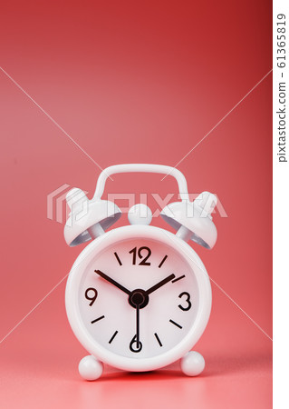 White retro alarm clock on pink background. 61365819