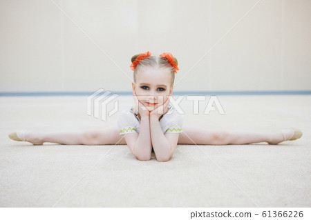 The girl sat down on the twine. classes in the fitness club. the girl is engaged in recreational gymnastics. sports exercises and stretching: athletics 61366226