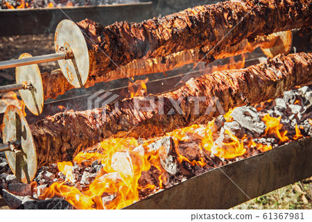 Spit roast meat on hardwood charcoal 61367981