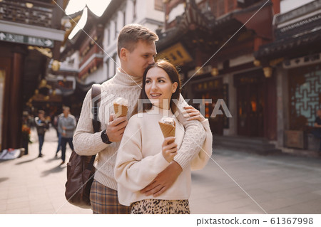 newlywed couple eating ice cream from a cone on a street in Shanghai near Yuyuan China. newlywed couple eating ice cream from a cone on a street in Shanghai near Yuyuan China. 61367998