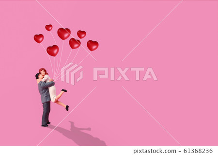 miniature couple standing and holding red love 61368236