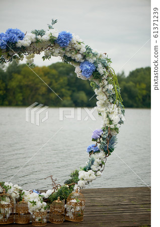 Round arch with white and blue flowers. Check-out on the river or lake.Wedding registration. 61371239