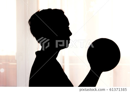 A woman holds a ball in her hands. 61371385