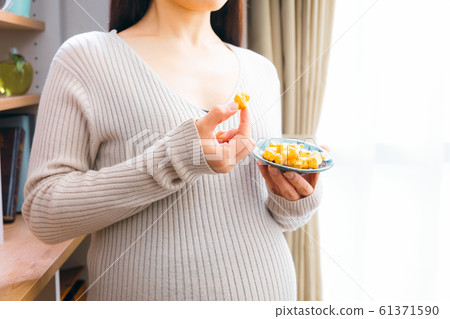 Pregnant woman eating okaki worried Pregnant woman eating okaki worried 61371590