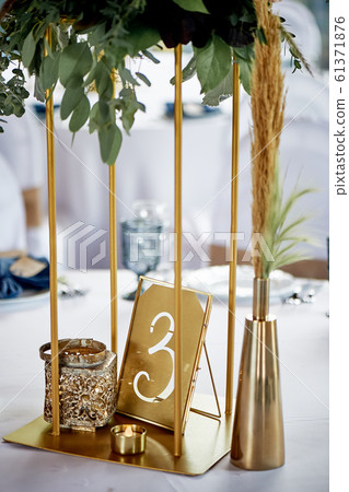 Stand metal thin with floral arrangement.And table number. Wedding floristry 61371876