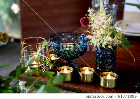 Decoration table newlyweds, blue dishes, bottles of flowers and candles.Wedding floristry. Decoration table newlyweds, blue dishes, bottles of flowers and candles.Wedding floristry. 61371899