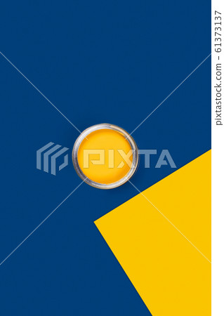 Two-toned background with yellow paint jar. 61373137