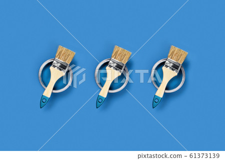 Blue background with paint jars and brushes. 61373139