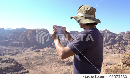 Hiker looking at map from mountain top Aerial shot 61373380