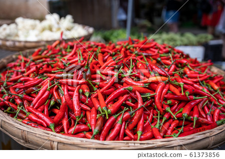 Red Chillies on sale a wicker bowl Red Chillies on sale a wicker bowl 61373856