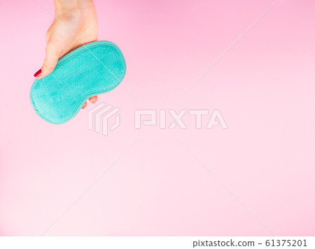 Female hands with manicure holding sleeping mask 61375201