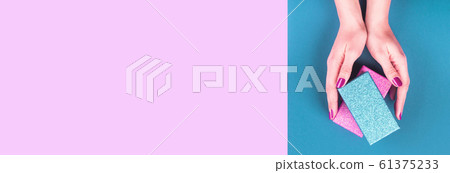 Hands with gift box on pink and classic blue 61375233