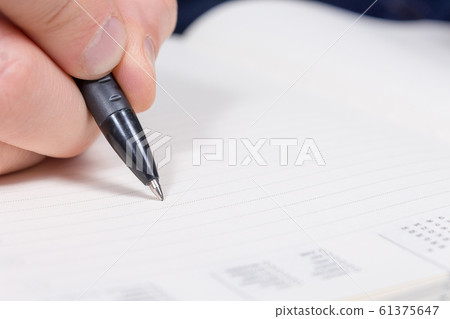 Personal finance. Young man writes in diary. 61375647