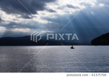 在山中湖中看到的天使梯子和釣魚者剪影 在山中湖中看到的天使梯子和釣魚者剪影 61375700