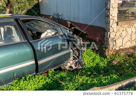 The car crashed into the wall, looking after the crash. Drunk driver. 61375778