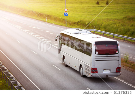 Bus on asphalt road in beautiful summer evening 61376355