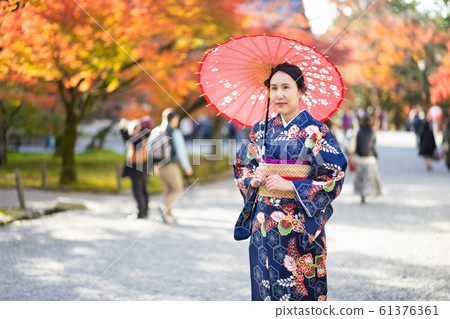 Geishas girl wearing Japanese kimono among red 61376361