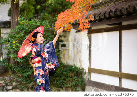 Geishas girl wearing Japanese kimono among red 61376370