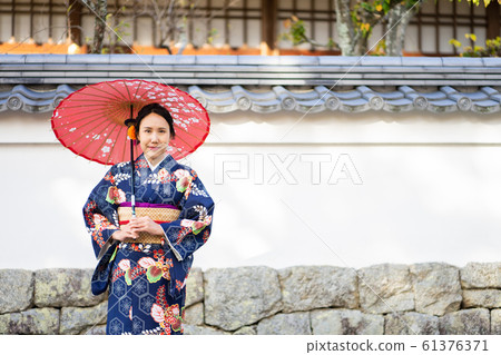 Geishas girl wearing Japanese kimono among red 61376371