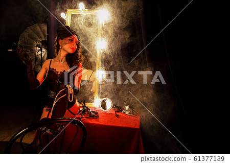Beautiful brunette girl burlesque holding a fan Beautiful brunette girl burlesque holding a fan 61377189