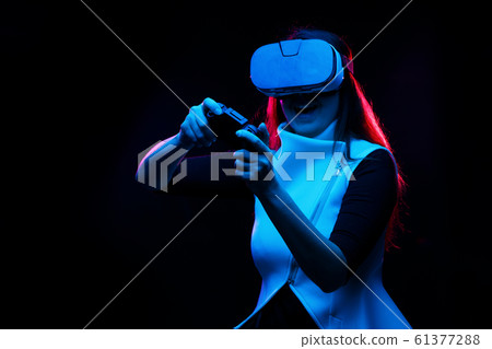 Woman with virtual reality headset is playing game. Woman with virtual reality headset is playing game. 61377288