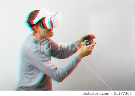 Man with virtual reality headset is playing game. Image with glitch effect. 61377305