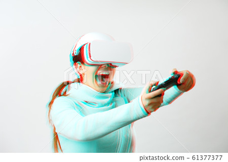 Woman with virtual reality headset is playing game. Image with glitch effect. 61377377