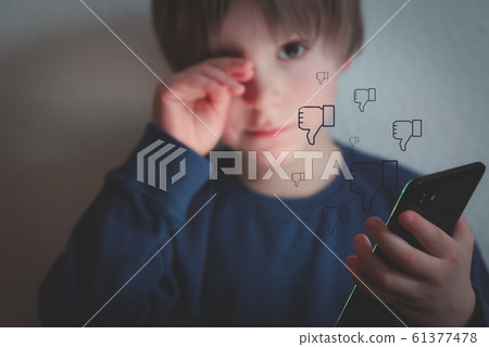 Cyber bullying concept - depressed boy with phone and negative comments 61377478