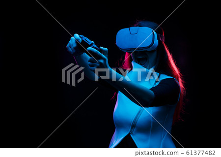 Woman with virtual reality headset is playing game. Woman with virtual reality headset is playing game. 61377482