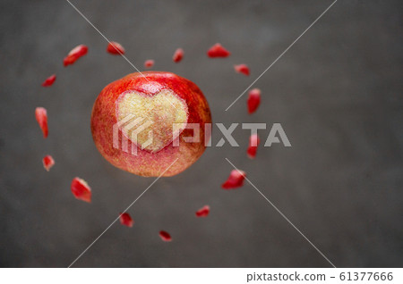 Pomegranate fruit peeled heart on grey background 61377666