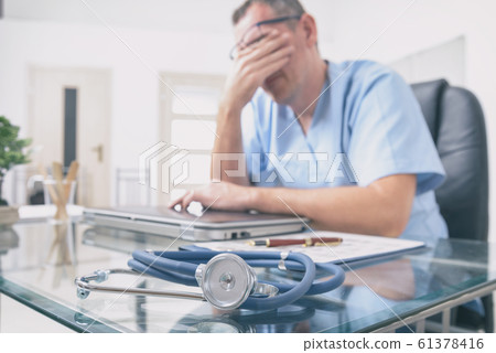 Overworked doctor in his office Overworked doctor in his office 61378416