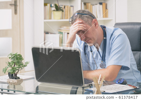 Overworked doctor in his office 61378417