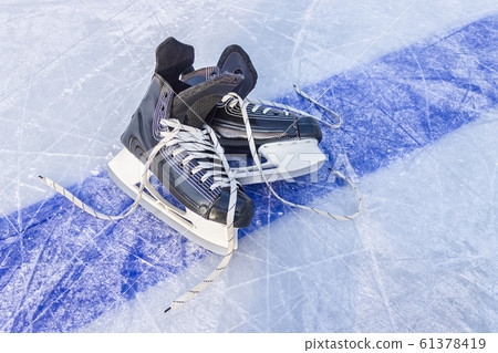 Sports black skates are on the hockey court. Winter Sports Equipment 61378419