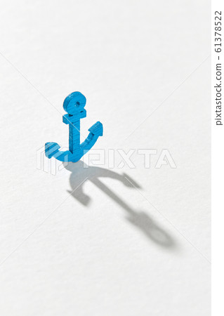 Blue emblem of anchor with long hard shadows. 61378522