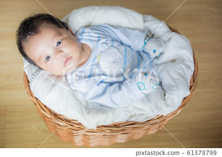 Adorable infant boy sleeping on small bed Adorable infant boy sleeping on small bed 61378799