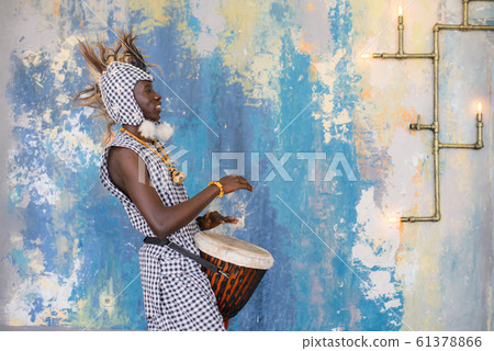 African artist in traditional clothes playing djembe drum African artist in traditional clothes playing djembe drum 61378866