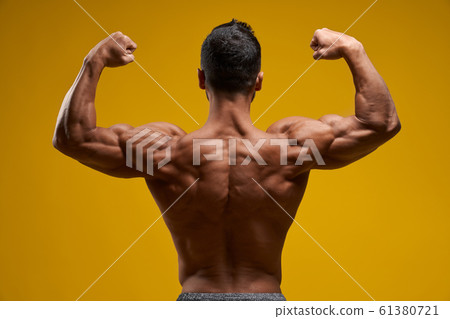 Shirtless man demonstrating muscular arms and shoulder 61380721