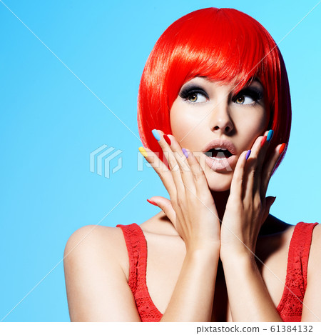 Surprised face of an young pretty woman with red 61384132